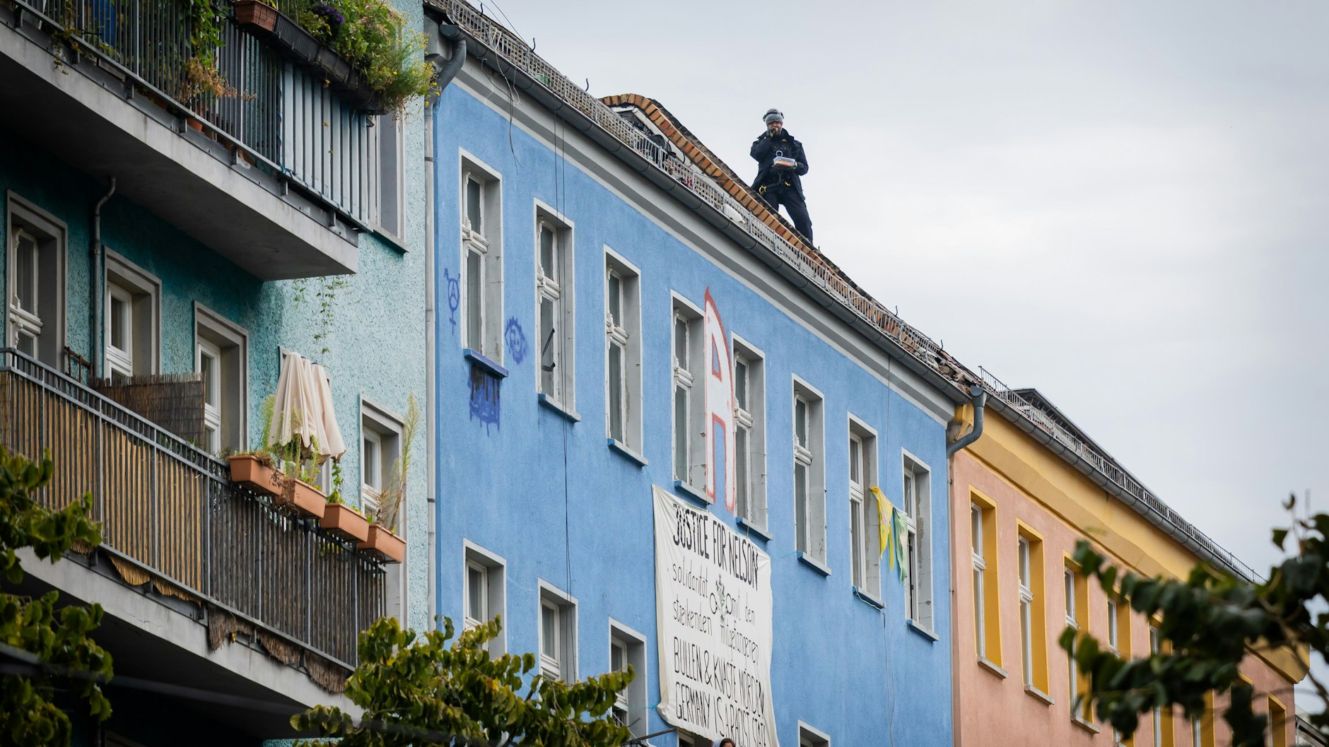 Entspannte Razzia: Ein Polizist isst auf dem Dach des besetzten Hauses Rigaer Straße 94 sein Pausenbrot.