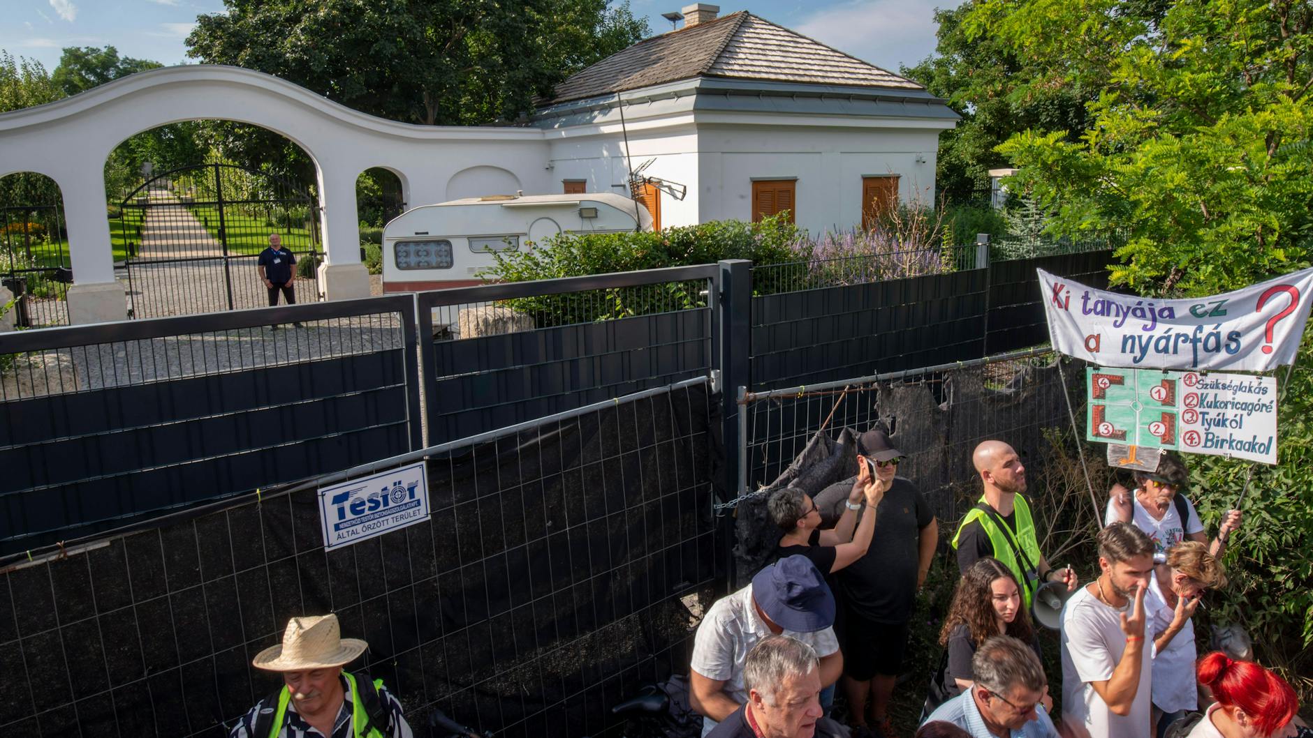 Proteste Anfang August vor dem Anwesen Hatvanpuszta in Ungarn. Die Hauptzufahrt ist verbarrikadiert, der Wohnwagen dahinter ist die Unterkunft der Security-Leute. Wem der Landsitz gehört, wollen die Demonstranten wissen.