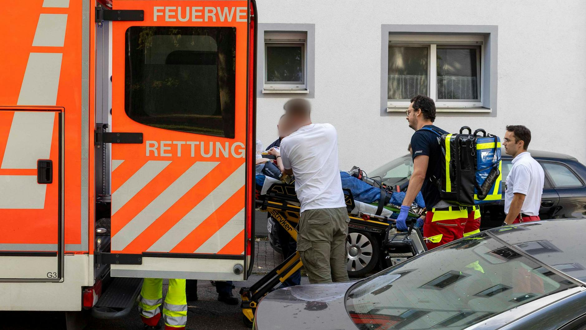 Eine verletzte Person wird an dem Berufskolleg in Essen zu einem Rettungswagen gebracht.