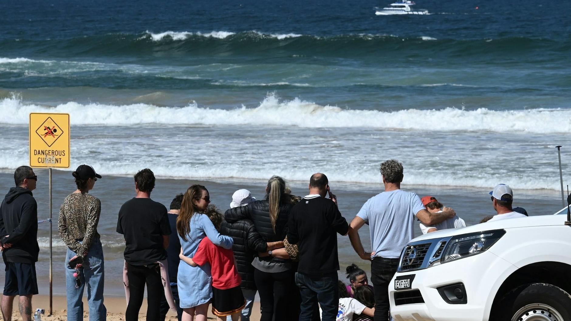 Familienangehörige und Freunde trauern am Ort eines tödlichen Haiangriffs am Long Reef Beach.