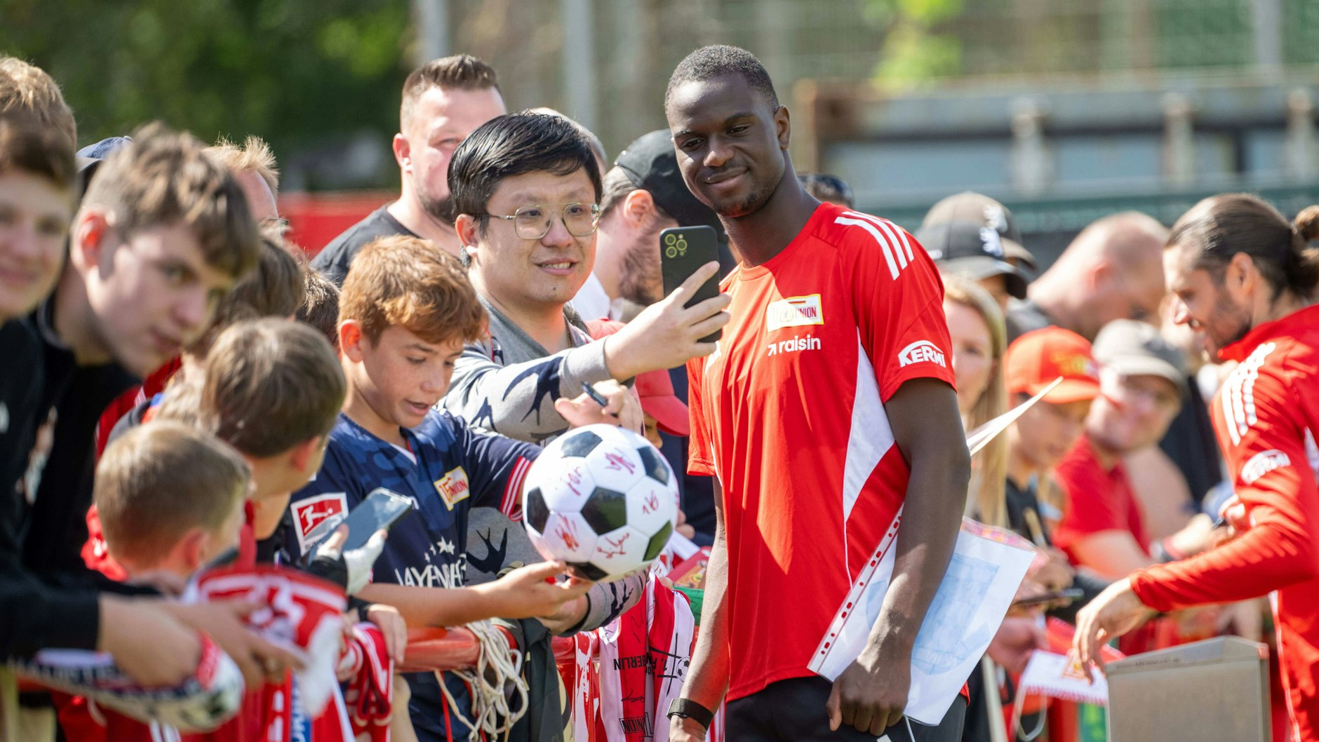 Ilyas Ansah posiert bei den Fans des 1. FC Union für ein Selfie.