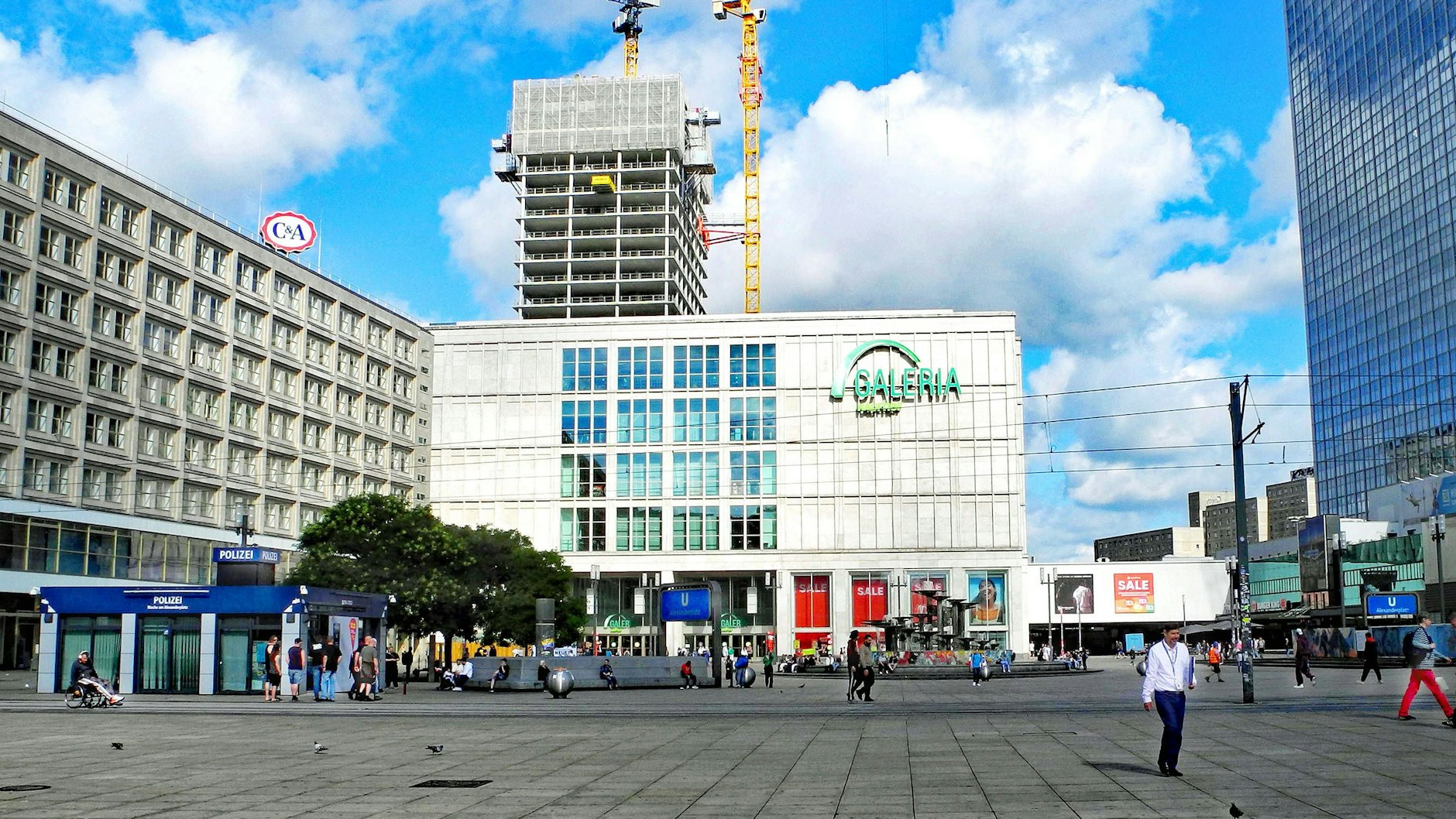 Das Galeria-Warenhaus am Berliner Alexanderplatz: Im Hintergrund wächst der 146 Meter hohe Wolkenkratzer, der an dem Gebäude angebaut wird.