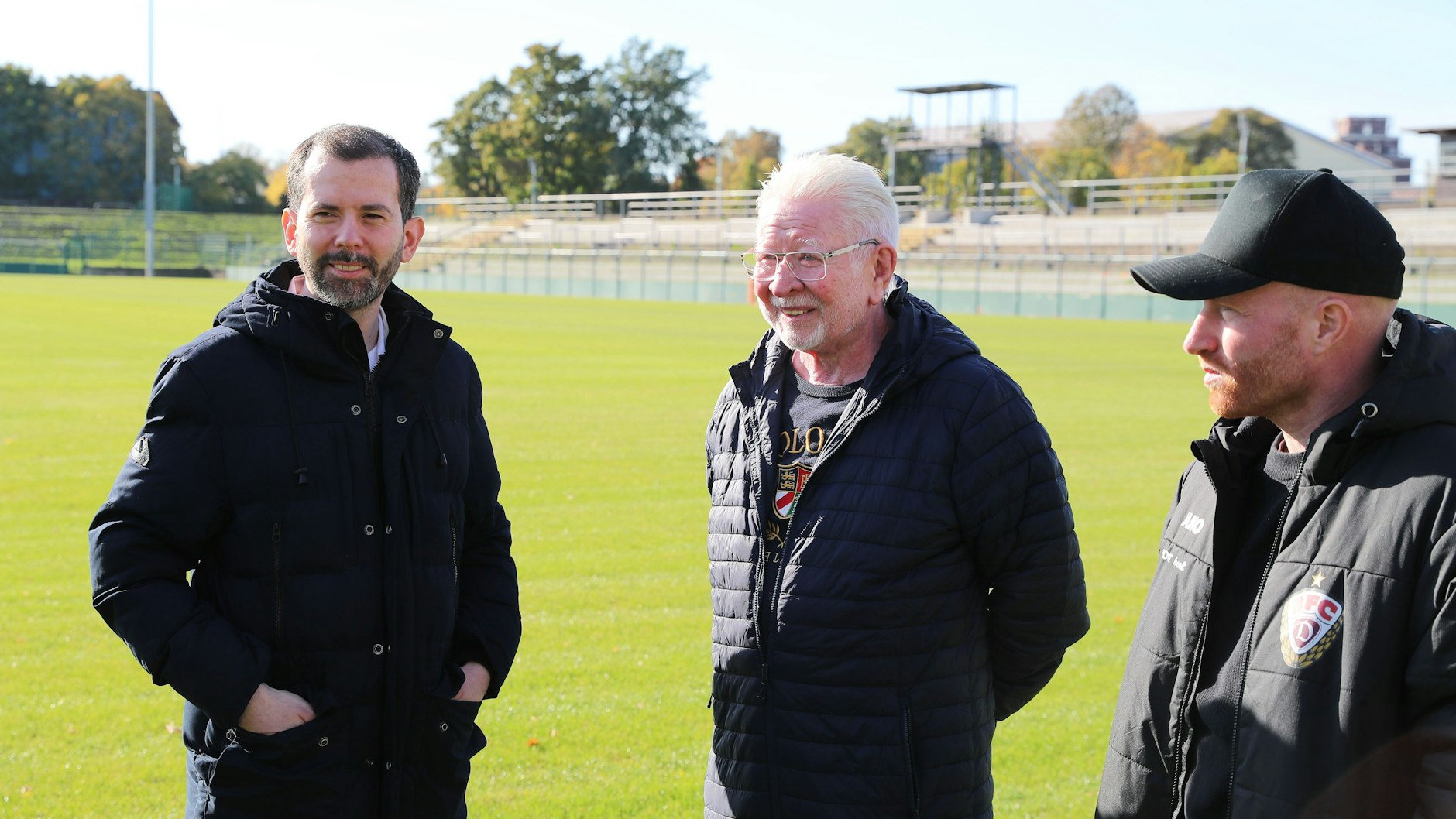 Martin Pätzold (CDU) steht mit Norbert Uhlig, Präsident des BFC Dynamo, und Jugendleiter Tobias Bluhm im Sportforum.