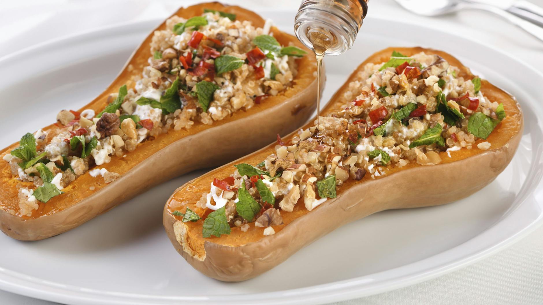 Der gebackene Butternut-Kürbis lässt sich zum Beispiel auch mit Walnüssen, frischer Minze und Quinoa füllen.