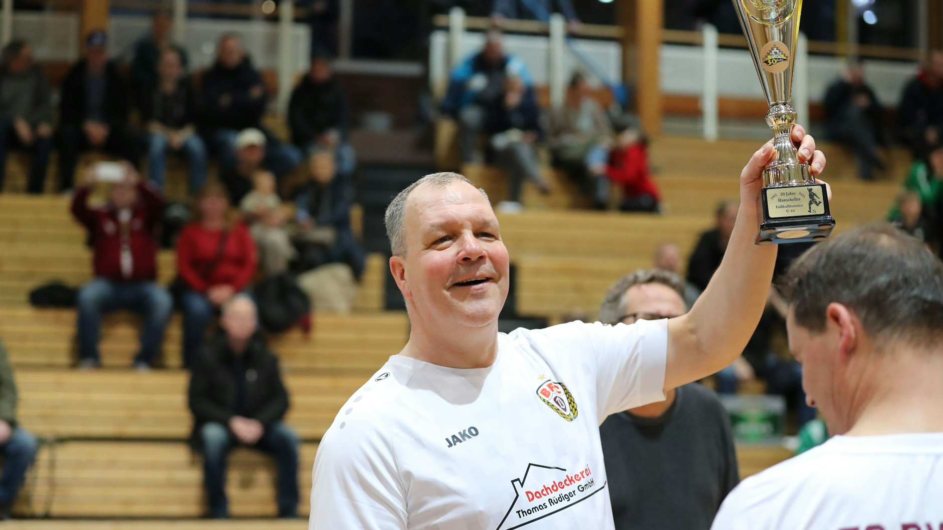 Jörn Lenz weiß, wie man gewinnt. Hier präsentiert der Kapitän der Traditionsmannschaft des BFC Dynamo den Pokal beim Gewinn des Hansekellercups in Stralsund im Januar 2025.