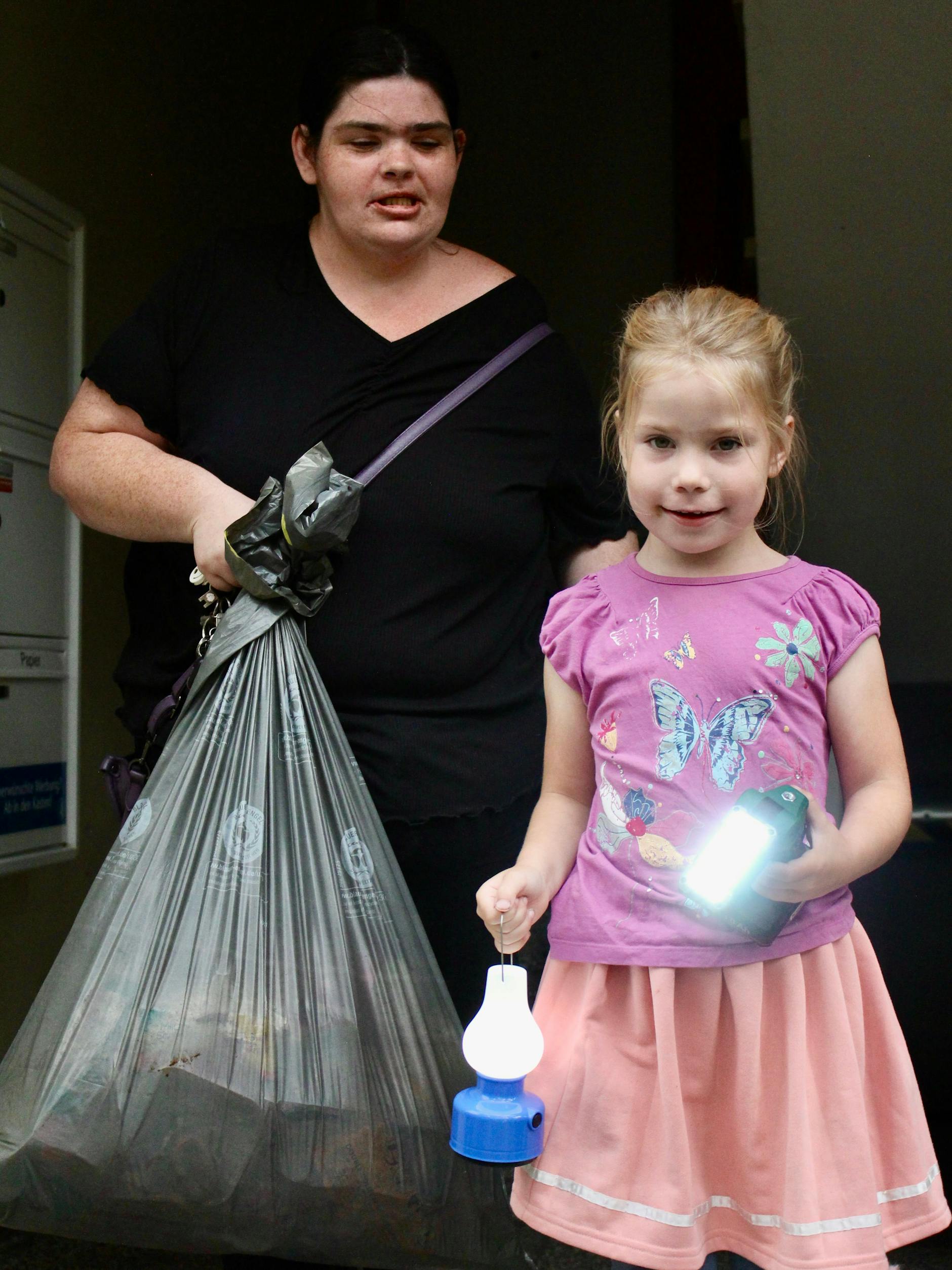 Mama Lydia und Tochter Samantha-Leonie bringen den Inhalt des Kühlschranks in den Müll. Für die Einschulung am Wochenende muss nun neu eingekauft werden.